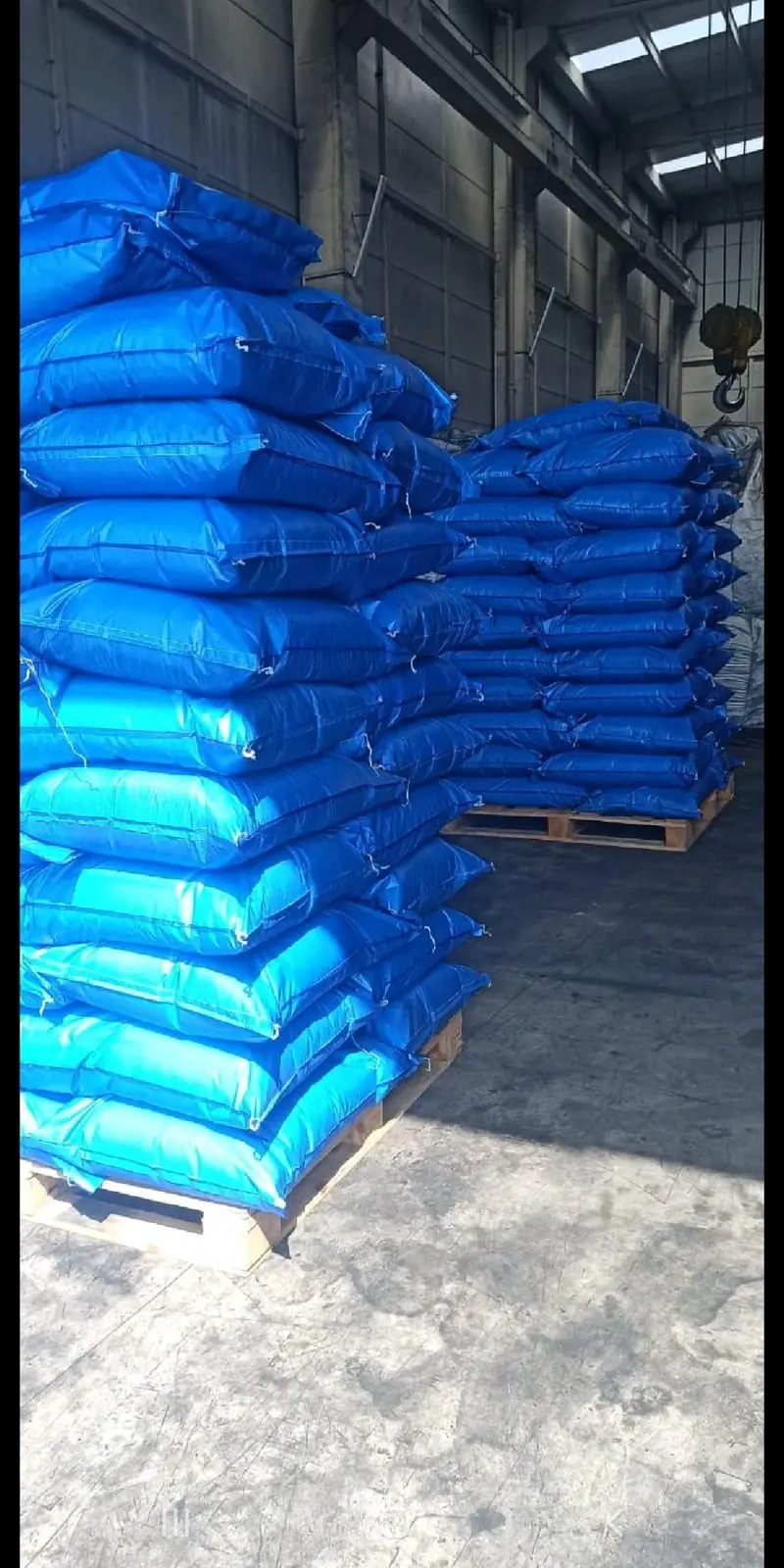 Blue activated carbon sacks stacked on pallets in the warehouse